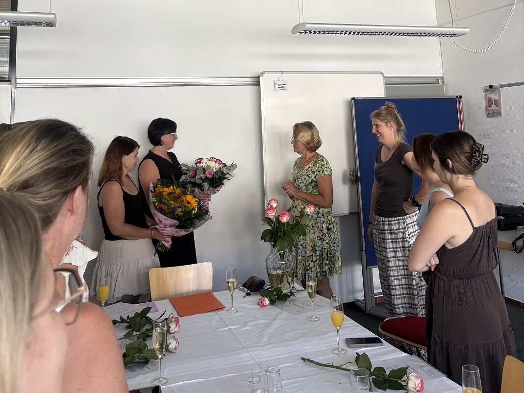 Seminarsituation einer Gratulation mit Blumensträußen