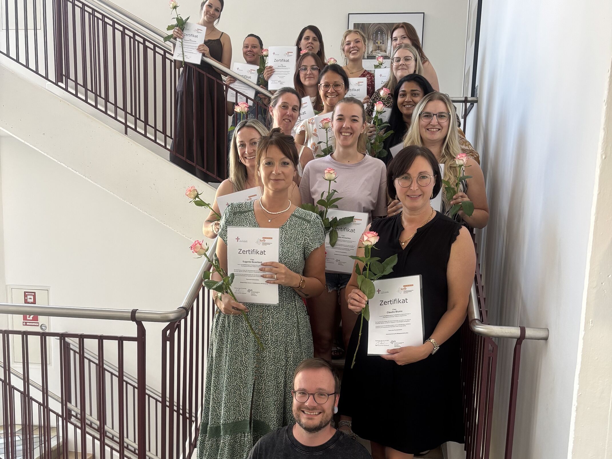 Mehrere Frauen stehen auf einer Treppe mit Ihrer Auszeichnung.